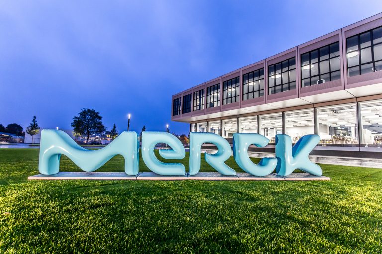 Merck Logo auf einer Wiese vor einem Gebäude