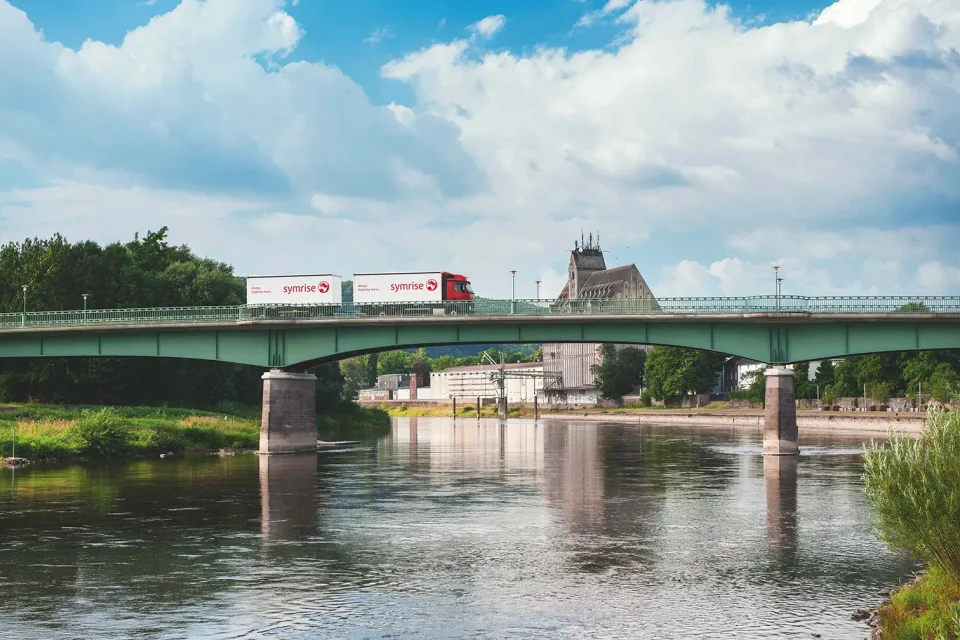 Ein LKW mit Symrise Firmenlogo, welcher über eine Brücke fährt