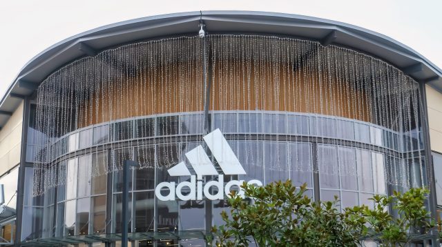 Das Adidas-Logo auf Glasfassade eines Outlet-Centers in Deutschland