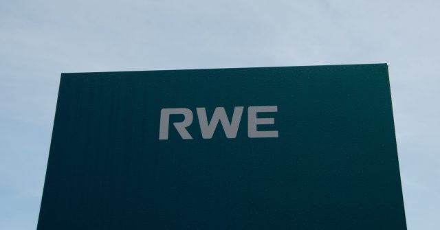 Ein blaues RWE-Schild mit blauem Himmel vor dem Wasserkraftwerk in Heimbach, Deutschland