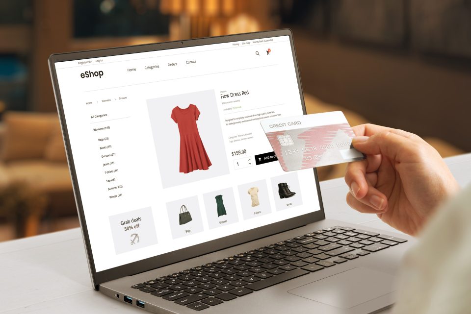 Moderne E-Commerce-Webseite mit einer Frau, die eine Kreditkarte in der Hand hält