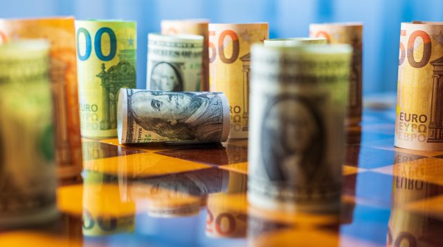 Dollar- und Euro-Noten auf einem Schachbrett