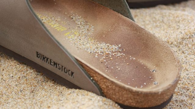 Birkenstock-Sandale im Sand