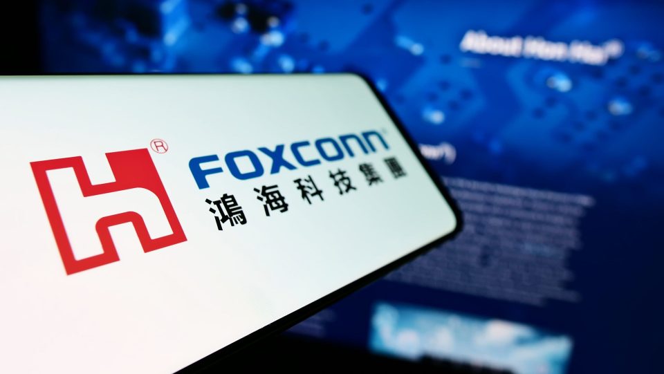 Stuttgart, Germany - 10-21-2022: Smartphone with logo of Hon Hai Precision Industry Co. Ltd. (Foxconn) on screen in front of business website. Focus on left of phone display.