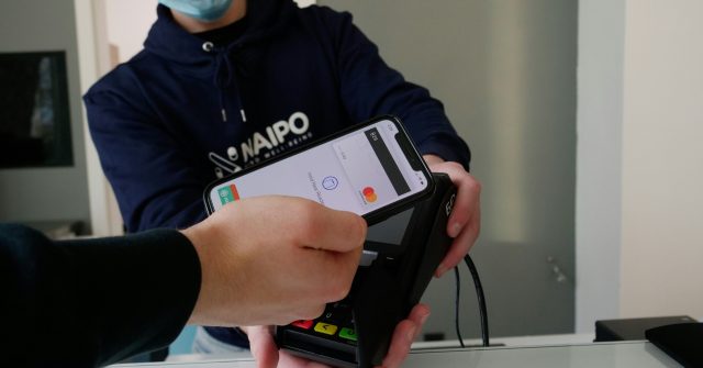 Eine Person zahlt mit mit seinem Smartphone mit Apple Pay